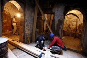Workers chop wood during the restoration of a Moorish