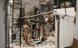 Residents stand near a damaged Moorish house in the