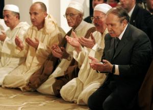 Algeria's President Abdelaziz Bouteflika (R) prays as they mark