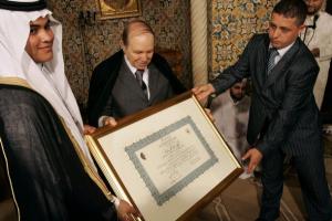Algeria's President Abdelaziz Bouteflika (C) presents a gift to