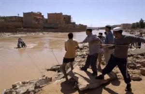 Residents help a man and two boys cross a