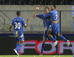 Portsmouth's Peter Crouch, center, celebrate with Armand Traore of