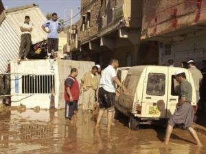 Residents stand in a flooded street of Ghardaia, 600