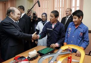 Algeria's President Abdelaziz Bouteflika (L) shakes hands with a