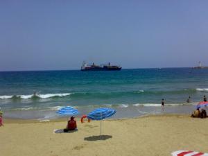 Un Bateau marchand vu depuis une plage de Skikda