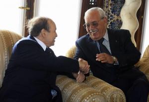 Algeria's President Abdelaziz Bouteflika (L) shakes hands with former