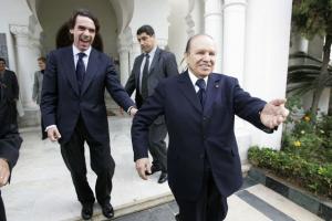 Algeria's President Abdelaziz Bouteflika (R) smiles as he walks
