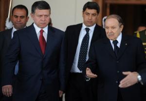 Algerian President Abdelazziz Bouteflika (R) escorts Jordan's King Abdullah