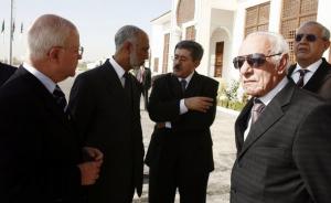 Algeria's Prime Minister Ahmed Ouyahia (C) talks to former
